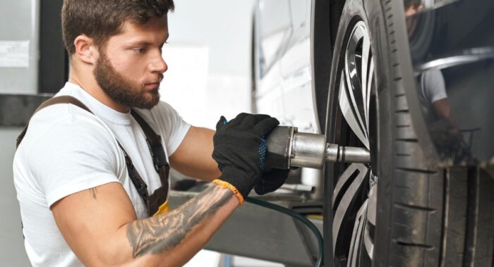 mec&aacute;nico revisando la alineaci&oacute;n y balanceo de llantas
