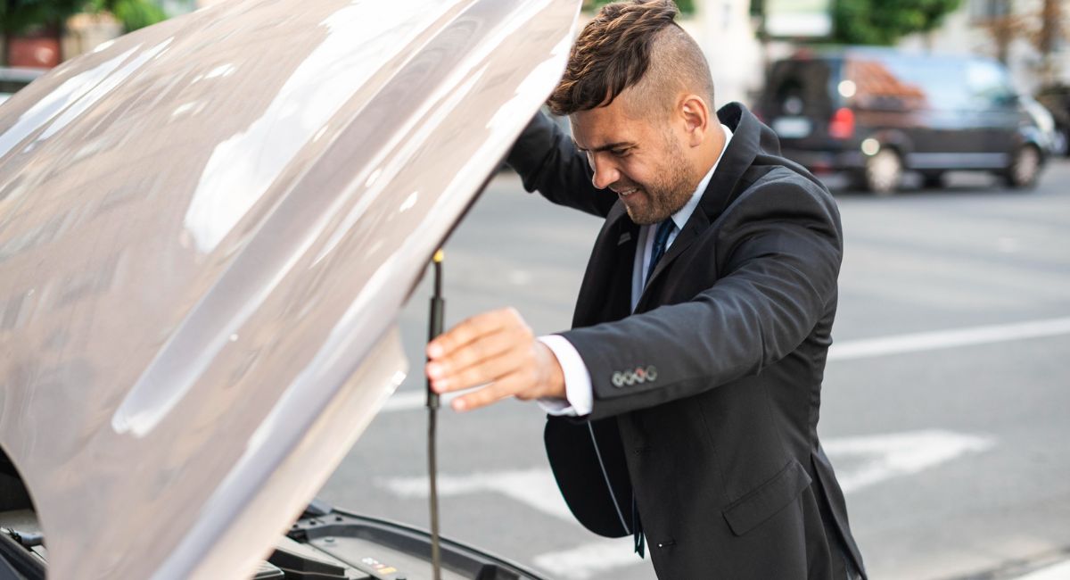 hombre revisando el sistema de encendido de su auto hombre revisando el sistema de encendido de su auto
